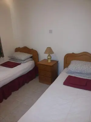 a bedroom with two beds and a lamp on a night stand at Apartments Mackenzie 1+1 in Larnaka