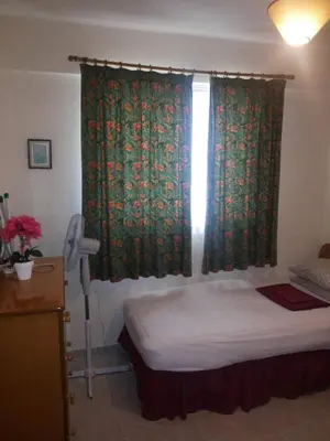 a bedroom with a bed and a window with curtains at Apartments Mackenzie 1+1 in Larnaka