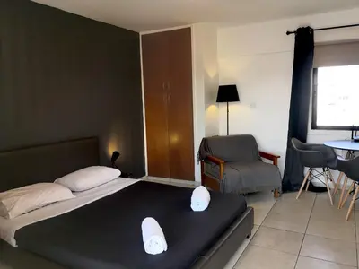 a bedroom with a bed and a table and a chair at St Lazaros, Larnaca Center Studio in Scala