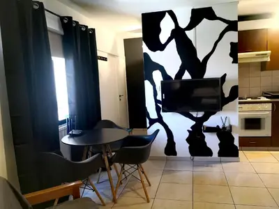 a living room with a tv and a table and chairs at St Lazaros, Larnaca Center Studio in Scala