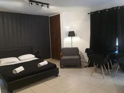 a bedroom with a bed and a chair and a table at St Lazaros, Larnaca Center Studio in Scala