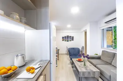 a kitchen and living room with a couch and a table at C-Premium Apts 100m from beach and city centre in Larnaka