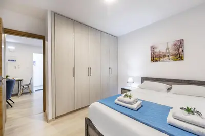 a bedroom with a large white bed and cabinets at C-Premium Apts 100m from beach and city centre in Larnaka