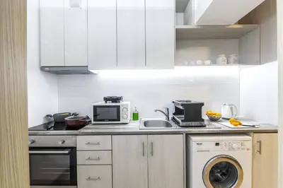 a kitchen with white cabinets and a microwave at C-Premium Apts 100m from beach and city centre in Larnaka