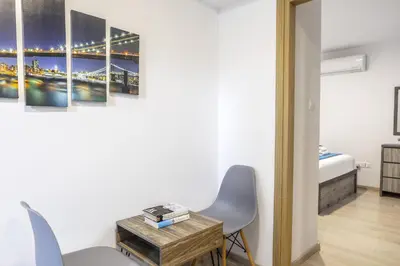 a room with a bed and a table and chairs at C-Premium Apts 100m from beach and city centre in Larnaka