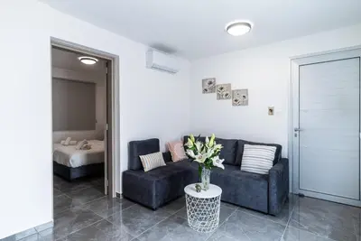a living room with a couch and a table with flowers at Spiros Luxury Apartments in Ayia Napa