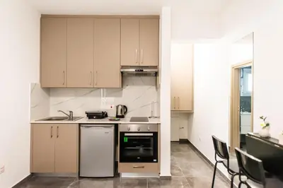 a small kitchen with white cabinets and appliances at Spiros Luxury Apartments in Ayia Napa