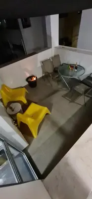 a living room with yellow chairs and a table at Spiros Luxury Apartments in Ayia Napa