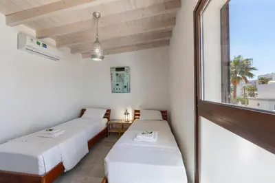 two beds in a room with a window at Protaras Villa Elena 3 in Protaras