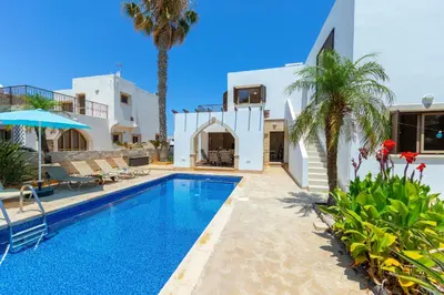 a villa with a swimming pool and a palm tree at Protaras Villa Elena 3 in Protaras