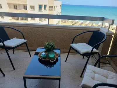 a table and chairs on a balcony with the ocean at Apollon Sea View Beachfront Ap 302 in Larnaka