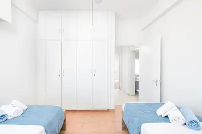 two beds in a room with white cabinets at Apollon Sea View Beachfront Ap 302 in Larnaka