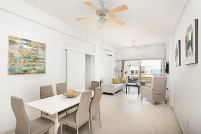 a dining room and living room with a ceiling fan at Apollon Sea View Beachfront Ap 302 in Larnaka