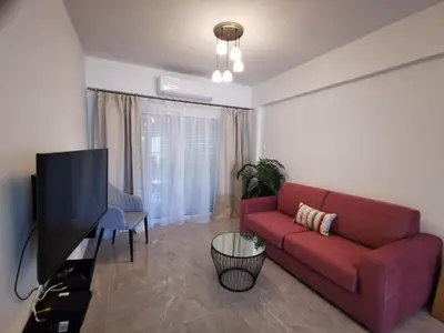 a living room with a red couch and a flat screen tv at Hawaii Holiday Apartment 41 in Limassol
