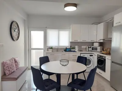 a kitchen with a table and chairs in a room at Hawaii Holiday Apartment 41 in Limassol