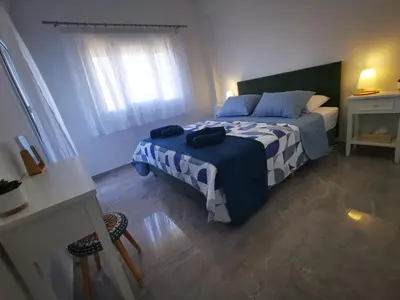 a bedroom with a bed with a blue and white comforter at Hawaii Holiday Apartment 41 in Limassol