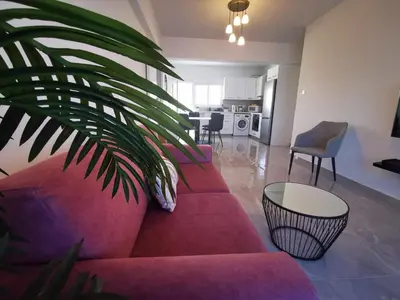 a living room with a red couch and a table at Hawaii Holiday Apartment 41 in Limassol