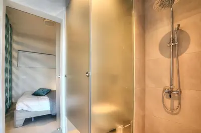 a bathroom with a shower and a bed in a room at SunnyVillas: NEW Studio SPA & GYM in Kapparis in Protaras