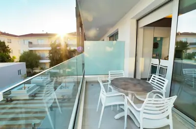 a glass balcony with a table and chairs on it at SunnyVillas: NEW Studio SPA & GYM in Kapparis in Protaras