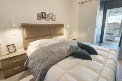 a bedroom with a large bed with pillows on it at SunnyVillas: NEW Studio SPA & GYM in Kapparis in Protaras