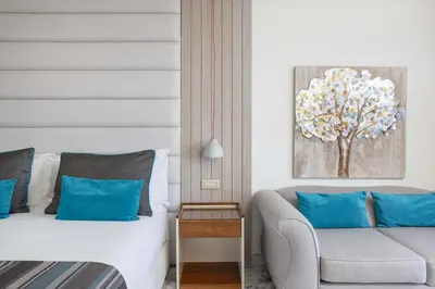a hotel room with a bed and a couch at Atlantica Bay - Adults Only in Limassol