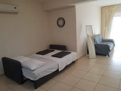 a bedroom with a bed and a chair and a clock at Larnaca Xylophagou 2-bedroom apartment with a shaded terrace in Xylophaghou
