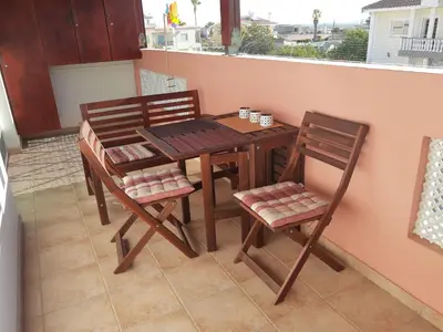 a table and chairs on a balcony with a table at Larnaca Xylophagou 2-bedroom apartment with a shaded terrace in Xylophaghou