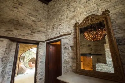 a mirror in a room with a stone wall at Whitestone Mill in Pano Lefkara