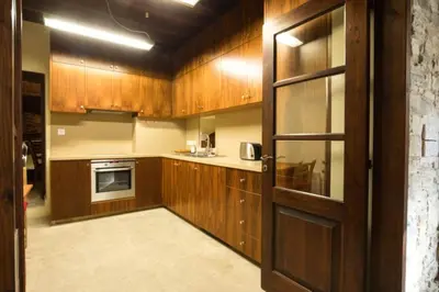 a kitchen with wooden cabinets and a door at Whitestone Mill in Pano Lefkara