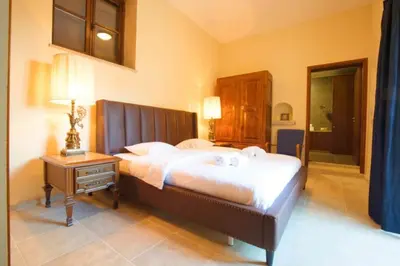 a bedroom with a large bed and a night stand at Whitestone Mill in Pano Lefkara