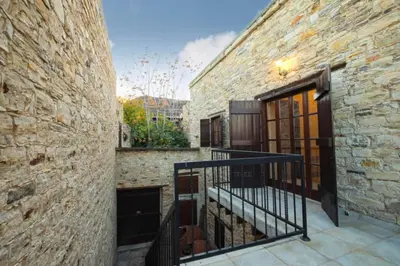 a stone building with a staircase next to a door at Whitestone Mill in Pano Lefkara