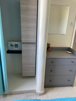 a bedroom with a bed and a dresser with a clock at Vitamin Sea Protaras in Protaras