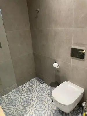 a bathroom with a toilet and a tiled floor at Vitamin Sea Protaras in Protaras
