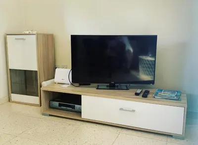 a flat screen tv sitting on a wooden entertainment center at Vitamin Sea Protaras in Protaras