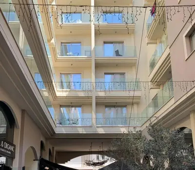 an apartment building with balconies in a shopping mall at Central Large Apt Next to the Beach in Larnaka