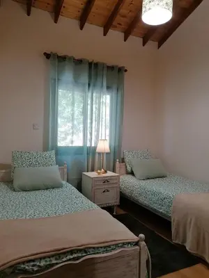 a bedroom with two beds and a window at House de Fountas in Khandria