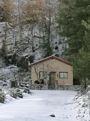 a small house with a snow covered yard at House de Fountas in Khandria