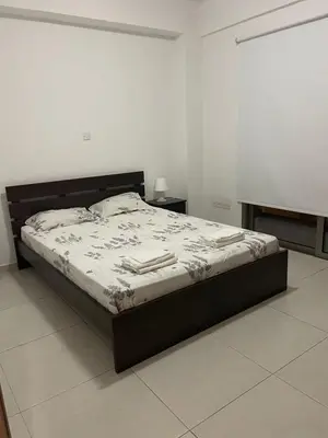 a bed in a white room with a bed frame at Central Large 2BD APT near the Beach in Larnaka
