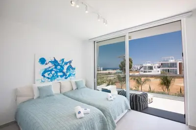a bedroom with two beds and a large window at Villa Olivine Pearl 3 in Protaras