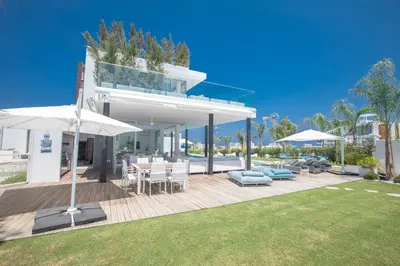 a house with a patio with a table and an umbrella at Villa Olivine Pearl 3 in Protaras