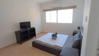 a living room with a bed and a television at 5 min to the Beach Holiday Shared Apartment - private ROOM in 3 bdr Apt in Larnaka