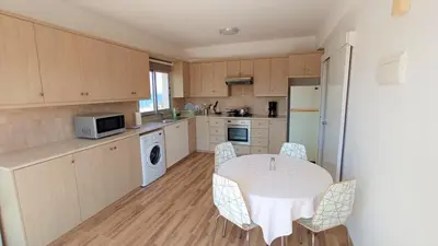 a kitchen with a table and chairs in a kitchen at 5 min to the Beach Holiday Shared Apartment - private ROOM in 3 bdr Apt in Larnaka