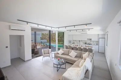 a living room with a couch and a kitchen at Kube Luxury Villas in Ayia Napa