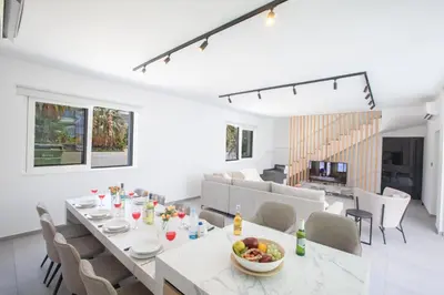 a dining room and living room with a table and chairs at Kube Luxury Villas in Ayia Napa