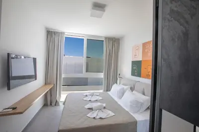 a hotel room with a bed with towels on it at Kube Luxury Villas in Ayia Napa