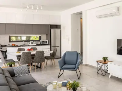 a living room and kitchen with a couch and chairs at Almaria Residences in Paralimni