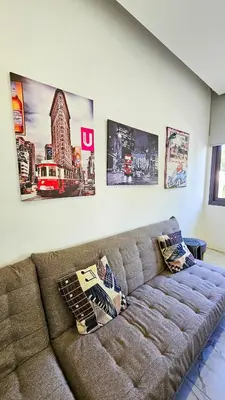 a couch in a living room with pictures on the wall at Mimi's Sunny Beach Apartment in Larnaka