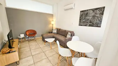 a living room with a couch and a table and chairs at FlipFlop City Center Apartment in Larnaka