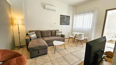 a living room with a couch and a table at FlipFlop City Center Apartment in Larnaka