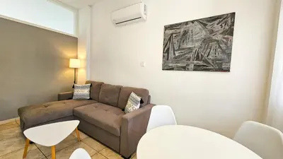 a living room with a couch and a table at FlipFlop City Center Apartment in Larnaka